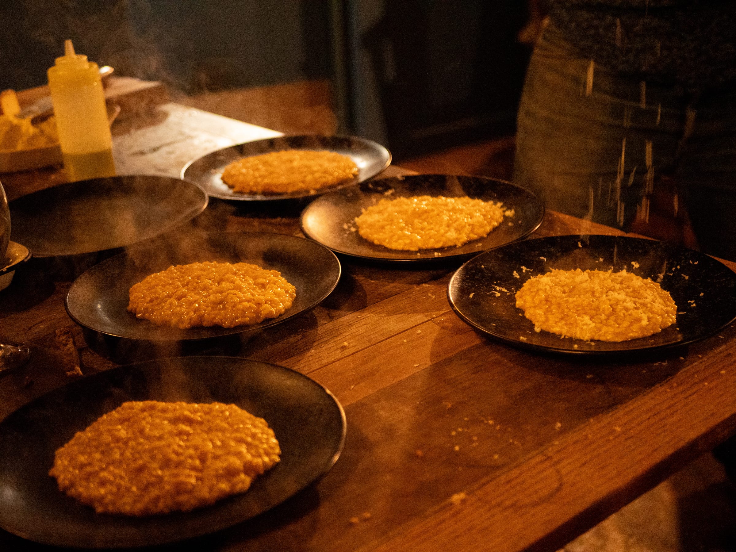 Plates on the pass, steam rising in the candlelight